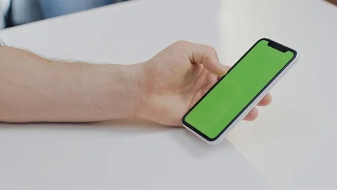 Close up of a green screen smartphone with a group of people around Stock Footage 104672458