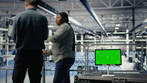 Close up of green screen tablet in front of data center engineers improving rigs Stock Footage 314804230