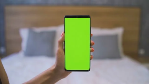 Close-up of green screen template smartphone in female hands at home in front of Stock Footage 137124631