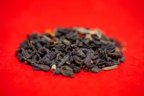 Close-up green tea leafy on a red background. Stock Photos