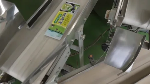 Close-Up of a Green Tea Packaging Machine Feed Chute Stock Footage 340010011