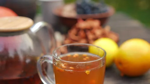 Close-up green tea in transparent cup with berries falling in beverage and Video stock 237513774