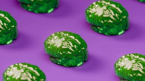 Close-up green translucent brains repeated in pattern with purple background. Stock Photos