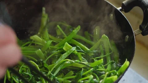 Close-up of green water spinach stir-fried in a hot iron pot in the kitchen Stock Footage 341506241