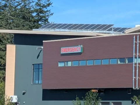 Close-up of green, white, and brown hospital featuring an emergency sign Stock Photos