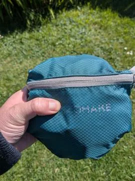 Close-up of green zip pouch containing fold-out backpack Foto stock