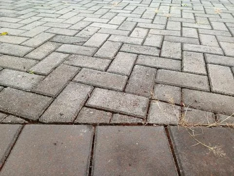 Close up of grey and brown interlocking brick pavement in herringbone patte.. Stock Photos