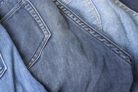 Close up of grey geans in a pile of blue jeans. Stock Photos