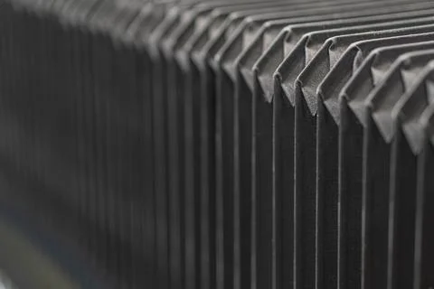 Close-up of grey, metallic structure with angular protrusions, uniform text.. Foto stock