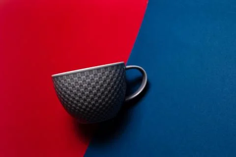 Close-up of grey mug on two backgrounds of red and blue of colors. Stock Photos