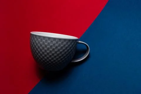 Close-up of grey mug on two backgrounds of red and blue of colors. Stock Photos
