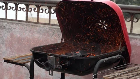 Close-up of a grill with charcoal throwing many sparks with fire from a Stock Footage 160087903