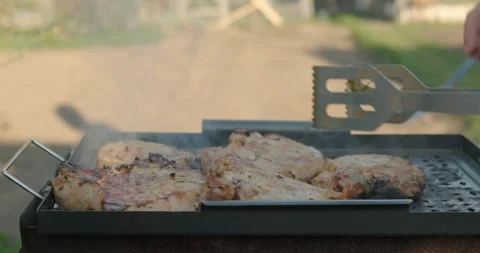 Close-up Grill. Chunks of Meat Laid out. Cooking tongs layout Filet along Grill Stock Footage 132982388
