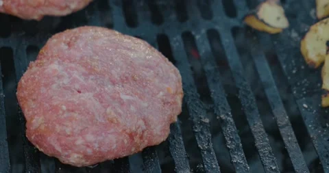 Close-up of grill, minced meat cut into cutlet, fried side, meat still raw Stock Footage 131036444