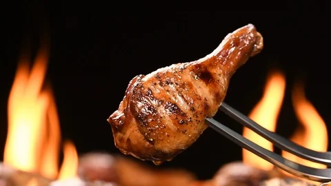Close up grill roast bbq chicken leg on the flaming grill . HD slow motion . Stock Footage 125411599