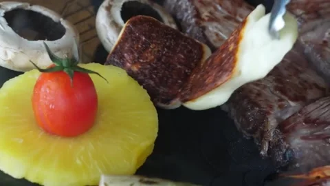 Close-up of Grilled Beef Steak with Pineapple, Halloumi Cheese, and Vegetables o Stock Footage 338210908