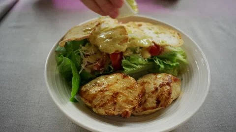 Close up of grilled chicken breast served with a fresh green salad including Stock Footage 335218239