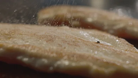 Close-up of grilled chicken breast sprinkled with salt. Slow Motion Video Stock Footage 114429613