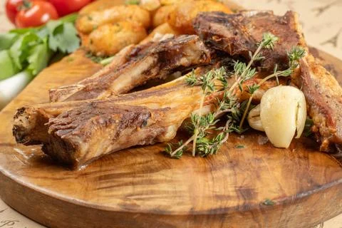Close-up of grilled lamb chops with fresh thyme and roasted garlic Stock Photos