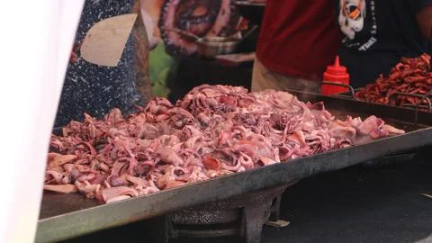 Close-up of grilled octopus and squid on a table with seafood at a street m.. Stock Photos