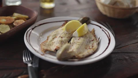 Close-Up of Grilled Trout with Lemon on Rustic Table Setting Stock Footage 336260923