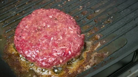 Close-up Grilling beef steak made from mince into a grilling frying pan in 4K. Stock Footage 153756368