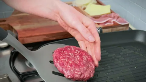 Close-up Grilling beef steak made from mince into a grilling frying pan in 4K. Stock Footage 153820837