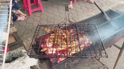 Close up grilling chicken over charcoal in the city street food. Lots of smoke Stockbeeldmateriaal 238917187