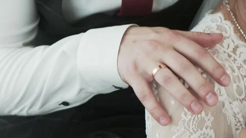 Close-up of the groom's hand gently stroking the bride's shoulder Stock Footage 317077707