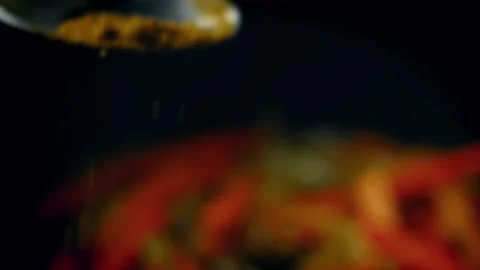 Close up of ground cumin sprinkled over onions and carrots in cooking pot Video stock 331639453