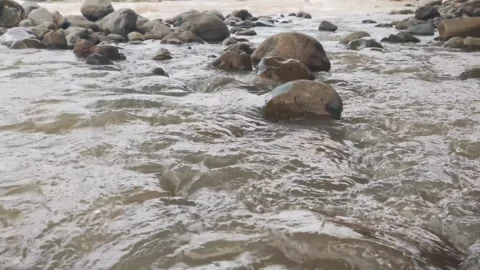 Close Up Ground Level Shot of Water Flowing Past River Rocks Stock Footage 342952719