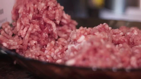 Close-Up of Ground Meat Falling onto Dark Glass Plate Stock Footage 334123275