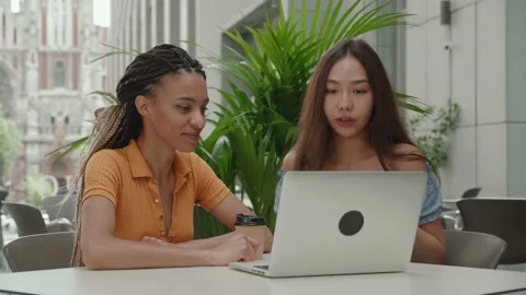 Close-up. group of 2 people sitting in cafe. Two student partners are working on Stock Footage 165333824