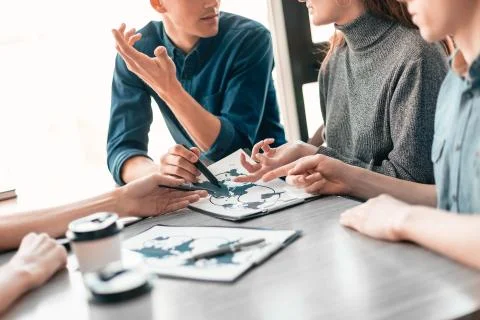 Close up. group of employees developing new logistics schemes. Elements of this Stock Photos