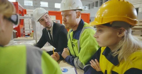 Close up of group of engineers discussing a production plan in a factory. Stock Footage 112063557