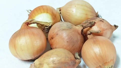 Close-up of a group of fresh raw yellow onions isolated on white background. 스톡 동영상 338991238