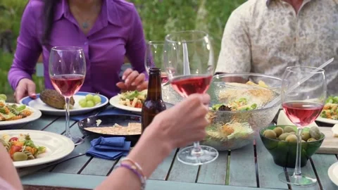 Close-up of a group of friends around the table at house patio diner. Video stock 219702565
