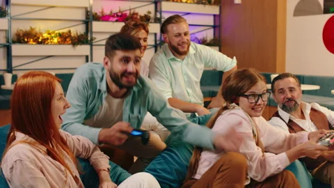 A close up of a group if people sitting on bean bag chairs whilst two people are Stock Footage 166916596