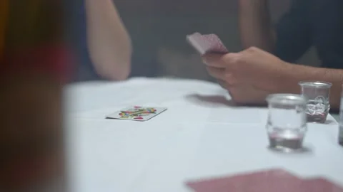 Close up of a group of men playing a tyrolean card game with a hearts card Stock Footage 220942285