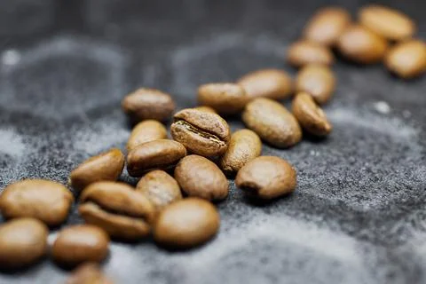 Close-up of a group of roasted coffee beans on a black baking tray background Stock Photos