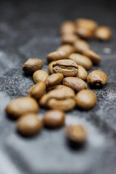 Close-up of a group of roasted coffee beans on a black baking tray background Stock Photos