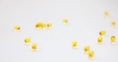 Close-up group of soft-gel capsule pills is poured onto a white surface. ca.. Stock Footage 265052614