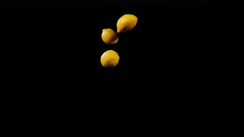 Close up at the group of three lemons fly up and spinning in slow motion Stock Footage 152789566