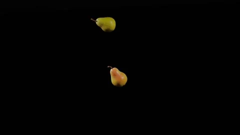 Close up at the group of two ripe yellow pears fly up and spinning Stock Footage 152789321