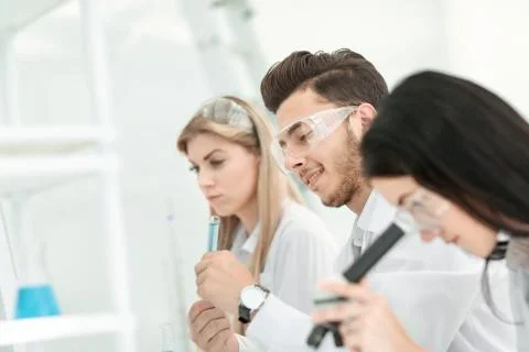 Close up.a group of young scientists conduct experiments in the laboratory. Stock Photos