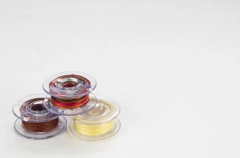 Close up groups of three sewing machine bobbins with colourful thread Stock Photos