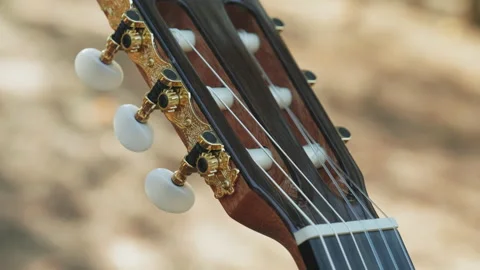Close-up of the guitar head of a classical guitar with gold pegs. Part of a c Stock Footage 219934283