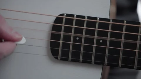 Close-Up of Guitar Strings Plucked with Pick, Vibration and Fade Stock Footage 328703745