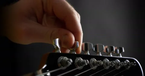 Close-up of the guitarist turns the knobs on the neck of the guitar. 스톡 동영상 169642675
