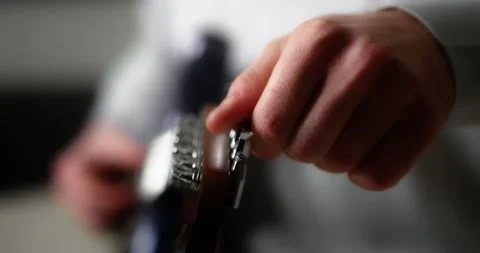 Close-up of the guitarist turns the knobs on the neck of the guitar. 動画素材 169643197